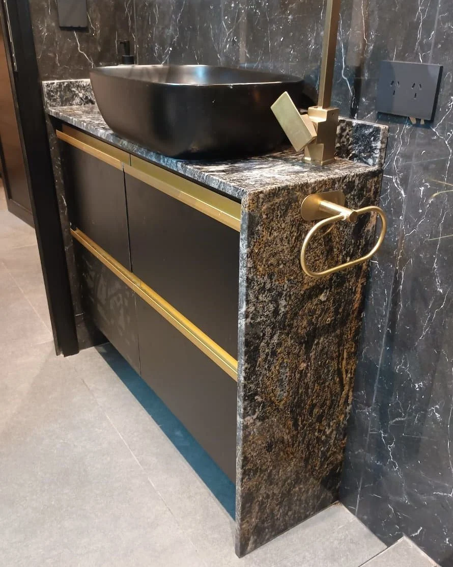 Detalle del granito Negro Boreal que continúa por el lateral del vanitory